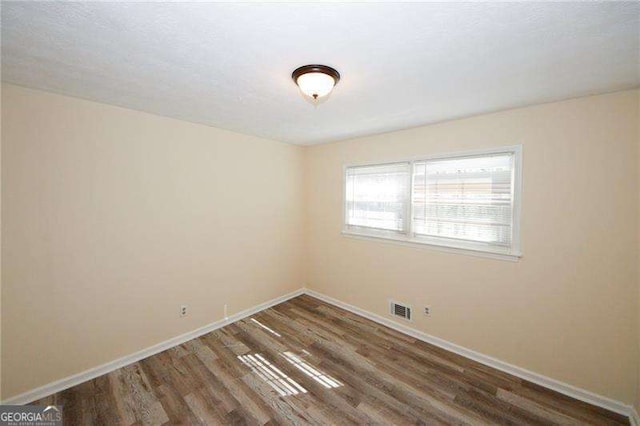 spare room featuring dark hardwood / wood-style flooring