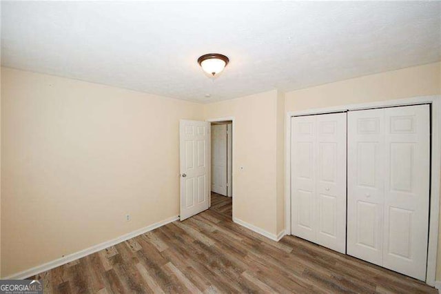 unfurnished bedroom with hardwood / wood-style flooring and a closet