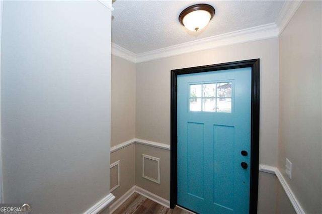 entryway with ornamental molding, a textured ceiling, and dark hardwood / wood-style flooring