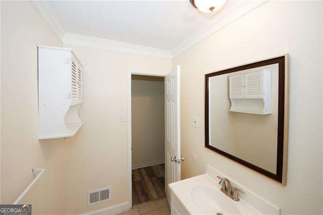 bathroom with crown molding, tile patterned floors, and vanity