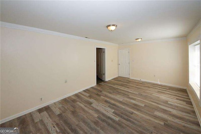 spare room with crown molding and dark wood-type flooring