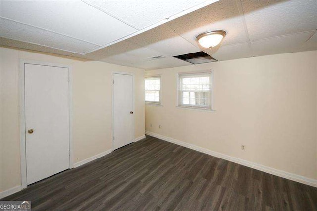 interior space featuring dark hardwood / wood-style floors and a drop ceiling