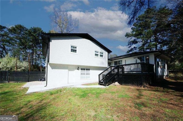 back of house featuring a yard and a deck