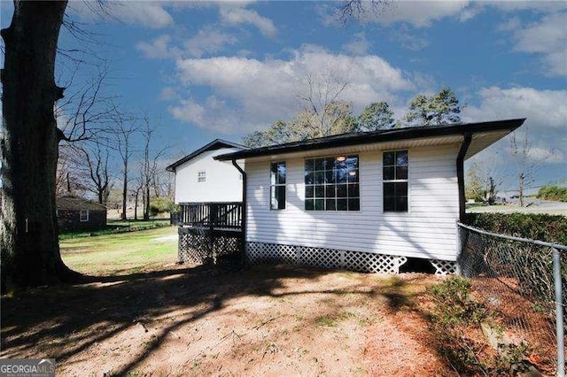 exterior space featuring a wooden deck and a lawn