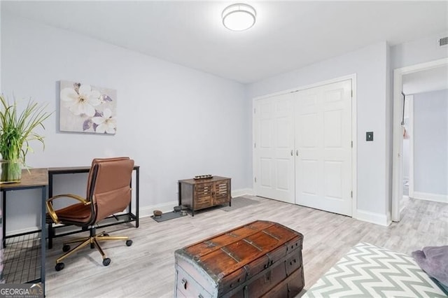 home office with light hardwood / wood-style flooring