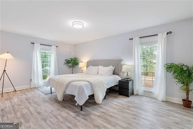 bedroom featuring multiple windows and light hardwood / wood-style floors