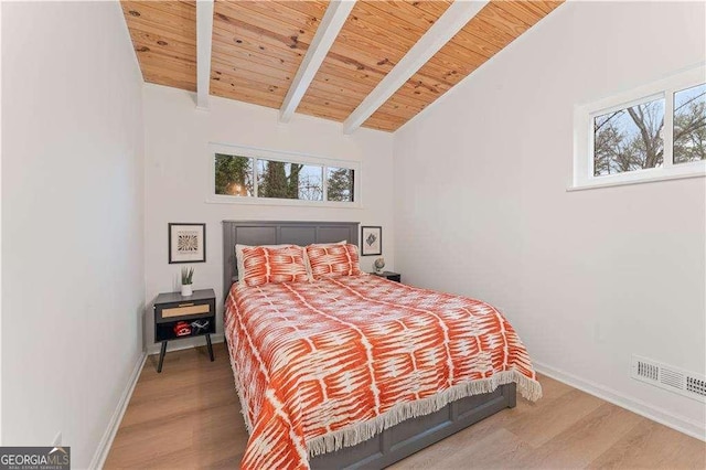 bedroom with multiple windows, vaulted ceiling with beams, wood ceiling, and wood-type flooring