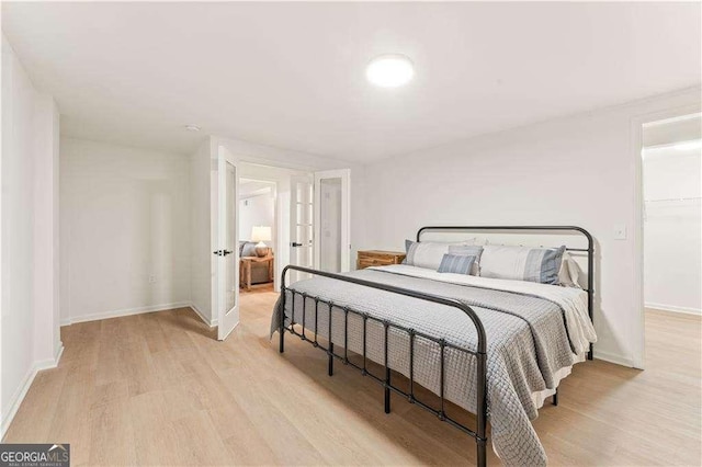 bedroom featuring a closet, light wood-type flooring, and french doors