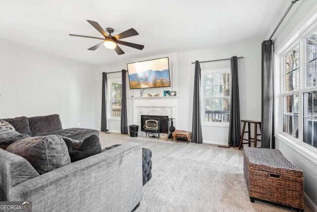 carpeted living room featuring ceiling fan and a high end fireplace