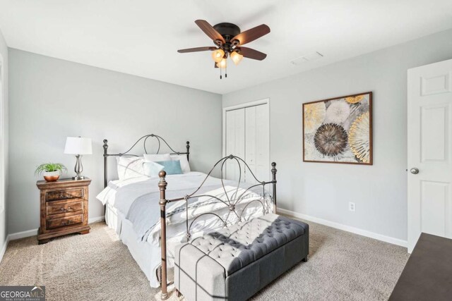 carpeted bedroom with ceiling fan and a closet