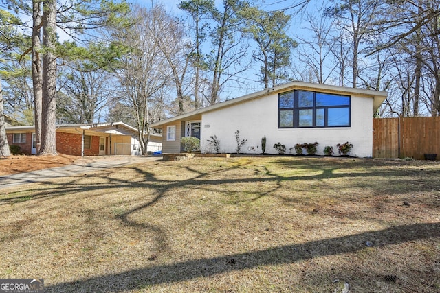 view of front of property featuring brick siding, fence, and a front yard