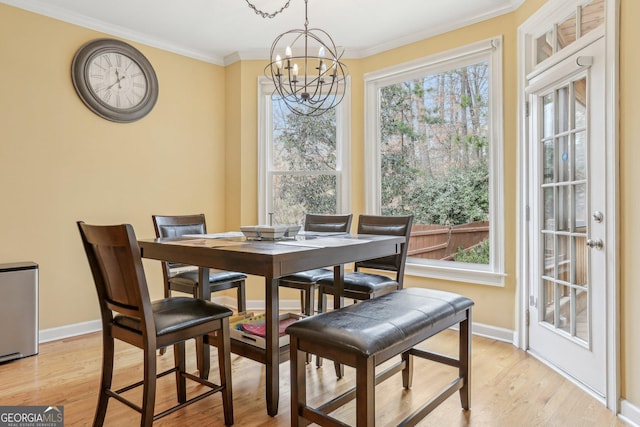 dining room featuring crown molding, a chandelier, and light wood-type flooring