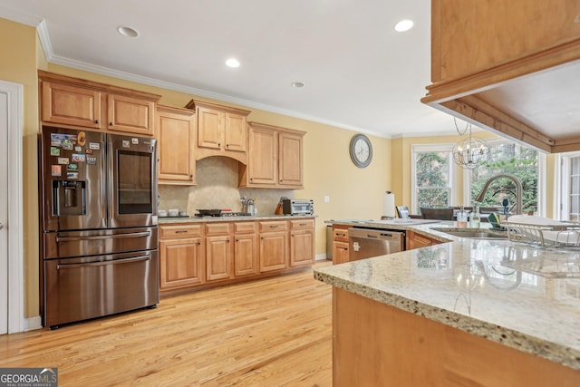 kitchen featuring sink, crown molding, appliances with stainless steel finishes, hanging light fixtures, and light stone counters