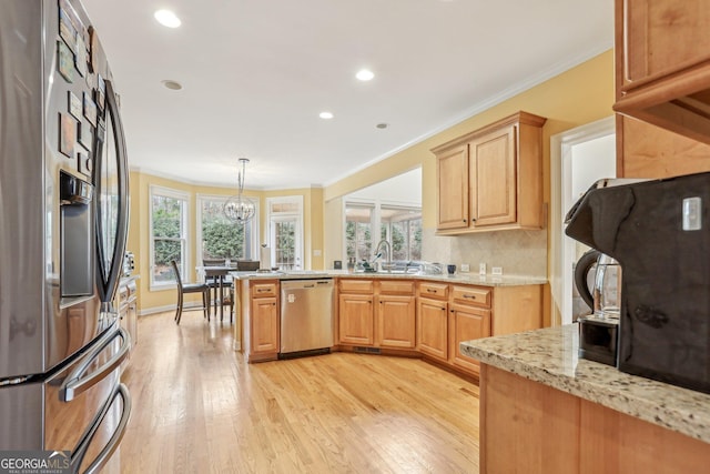 kitchen with sink, crown molding, a wealth of natural light, and stainless steel appliances