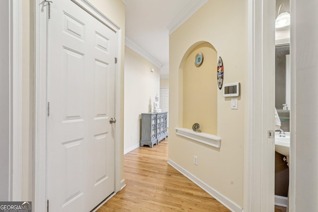 hallway featuring crown molding and light wood-type flooring