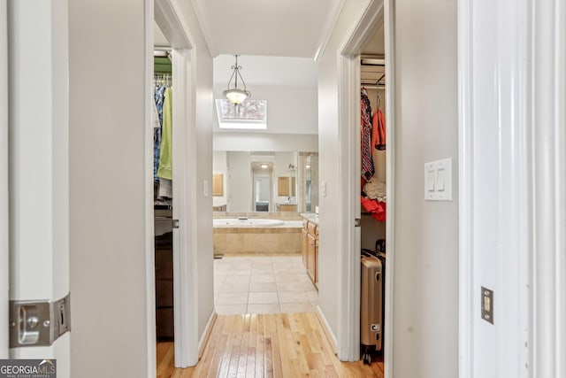 hall with crown molding and light wood-type flooring