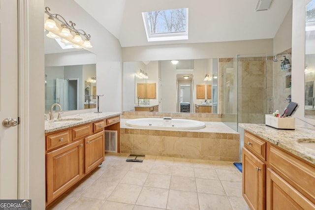 bathroom featuring tile patterned flooring, vanity, independent shower and bath, and vaulted ceiling with skylight