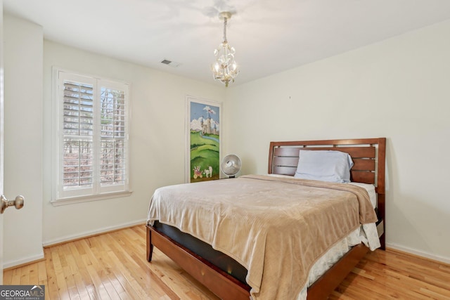 bedroom featuring hardwood / wood-style flooring and a chandelier