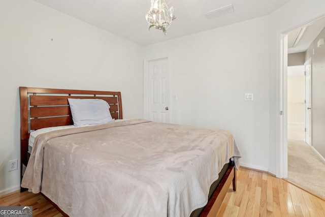 bedroom with a chandelier and light hardwood / wood-style flooring