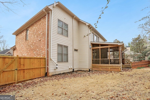 rear view of house featuring a sunroom