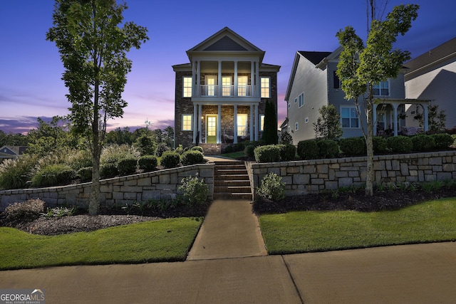 view of front of home featuring a yard and a balcony