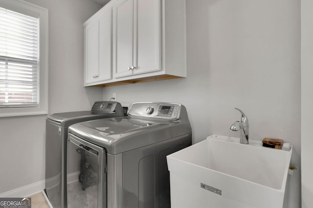 washroom with washing machine and dryer, cabinets, and sink