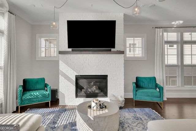 living room with a fireplace, crown molding, and dark hardwood / wood-style flooring