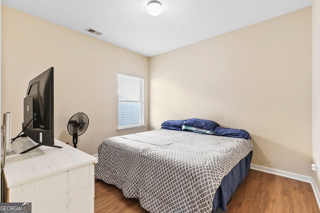 bedroom with dark hardwood / wood-style flooring