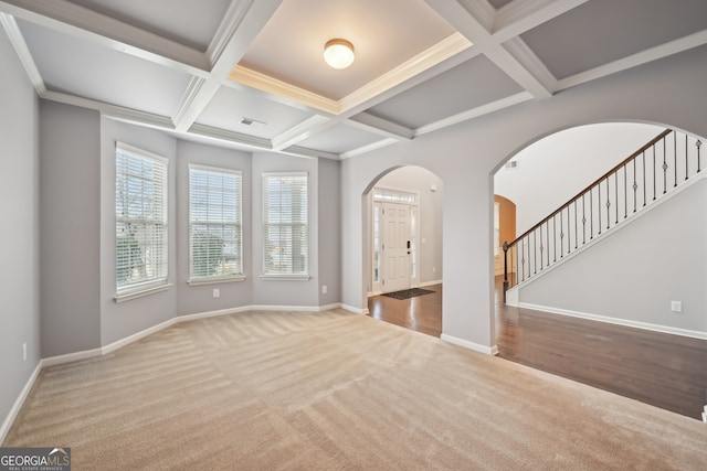 unfurnished living room with coffered ceiling, ornamental molding, carpet flooring, and beam ceiling