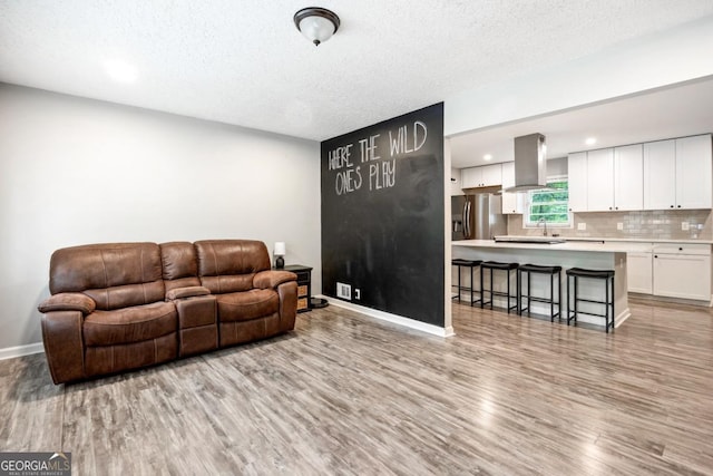 living room with a textured ceiling and light hardwood / wood-style flooring