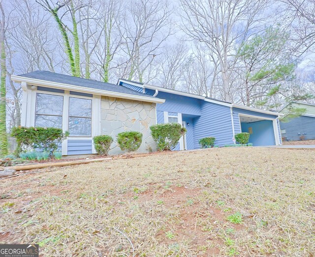 single story home featuring a garage and a front lawn