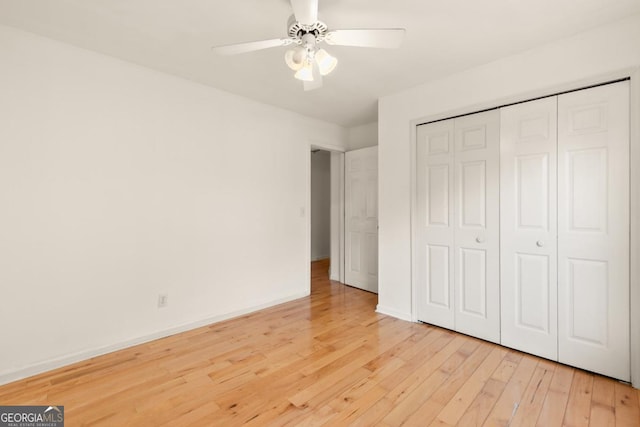 unfurnished bedroom featuring a closet, light wood-type flooring, a ceiling fan, and baseboards