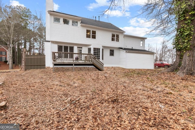 back of property featuring a chimney and a wooden deck