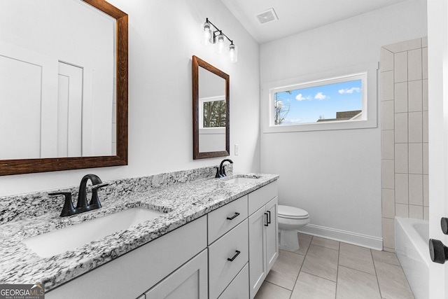 full bathroom with tile patterned flooring, vanity, tiled shower / bath, and toilet