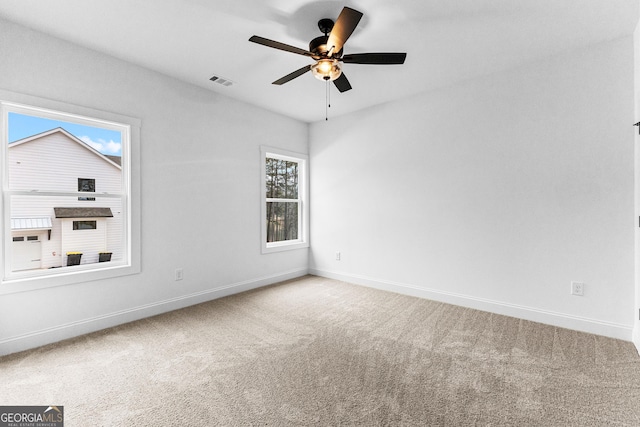 carpeted spare room with ceiling fan