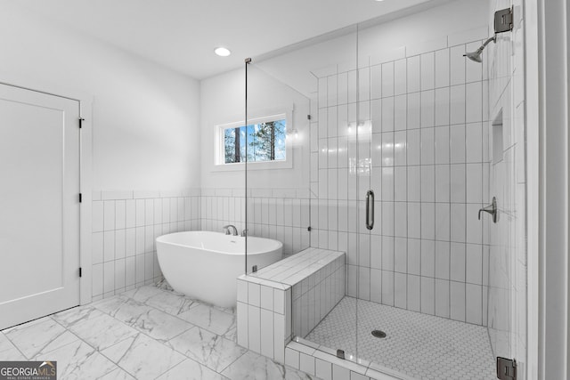 bathroom featuring tile walls and independent shower and bath