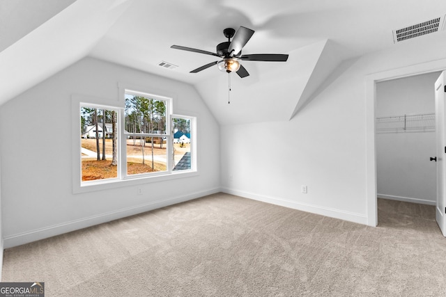 additional living space with vaulted ceiling, light carpet, and ceiling fan