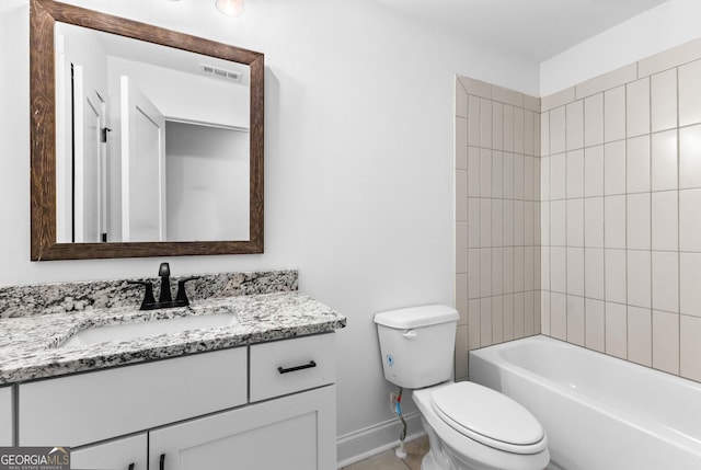 full bathroom featuring vanity, tiled shower / bath, and toilet