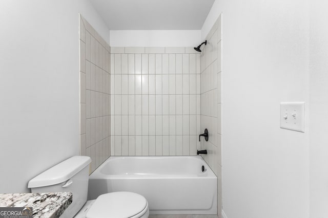 bathroom with tiled shower / bath combo and toilet