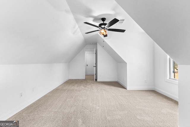 additional living space with lofted ceiling, light colored carpet, and ceiling fan