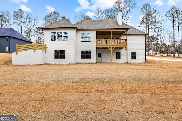 back of property with a balcony and a lawn