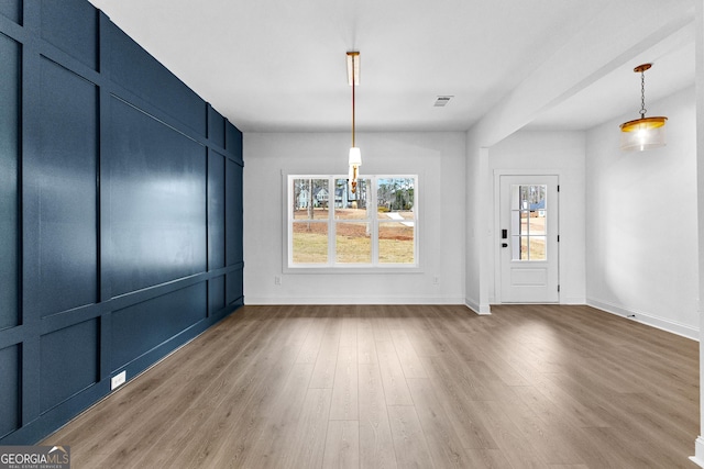 unfurnished dining area featuring plenty of natural light and hardwood / wood-style floors