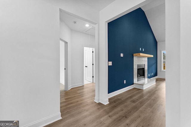 unfurnished living room with a tiled fireplace and hardwood / wood-style flooring