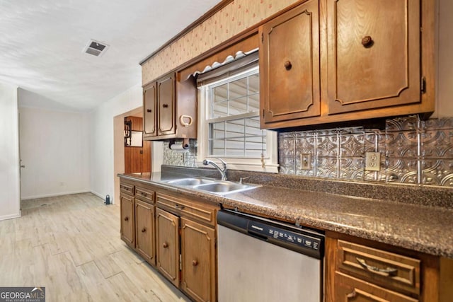 kitchen featuring stainless steel dishwasher, light hardwood / wood-style floors, and sink