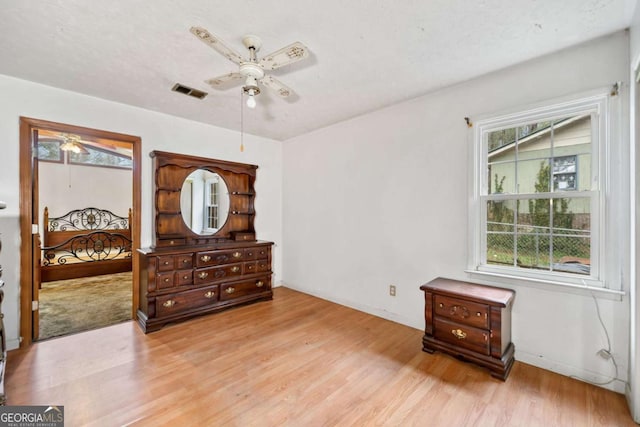 bedroom featuring a textured ceiling, light hardwood / wood-style flooring, and ceiling fan