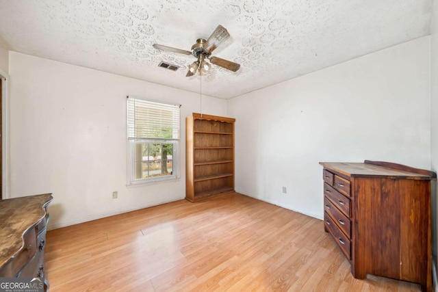 interior space featuring ceiling fan, a textured ceiling, and light wood-type flooring