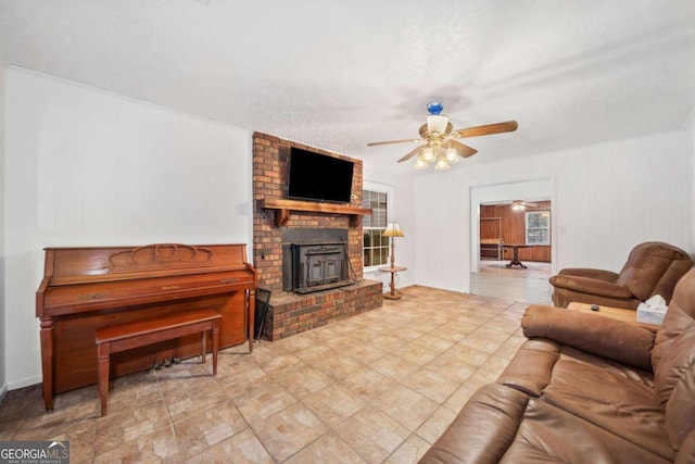 living room with a wood stove and ceiling fan