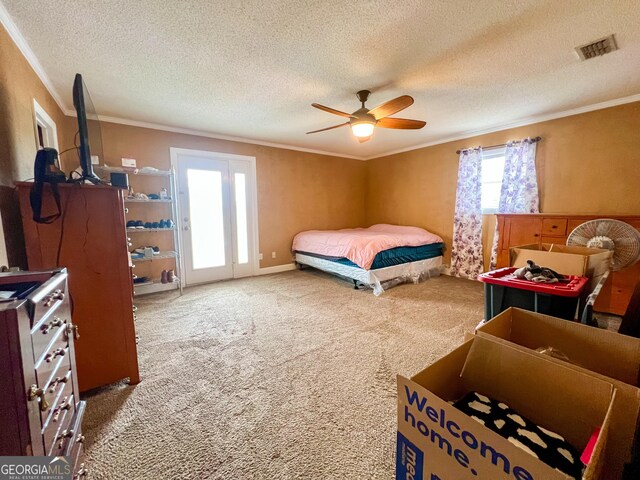 carpeted bedroom featuring a textured ceiling, ornamental molding, and ceiling fan