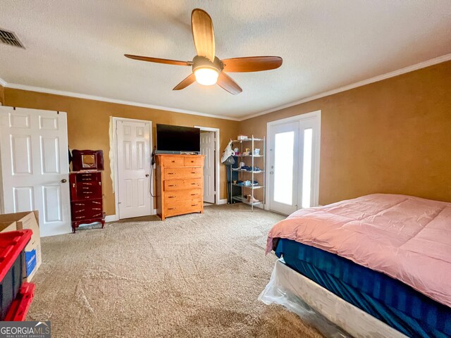 carpeted bedroom with ceiling fan, ornamental molding, and a textured ceiling