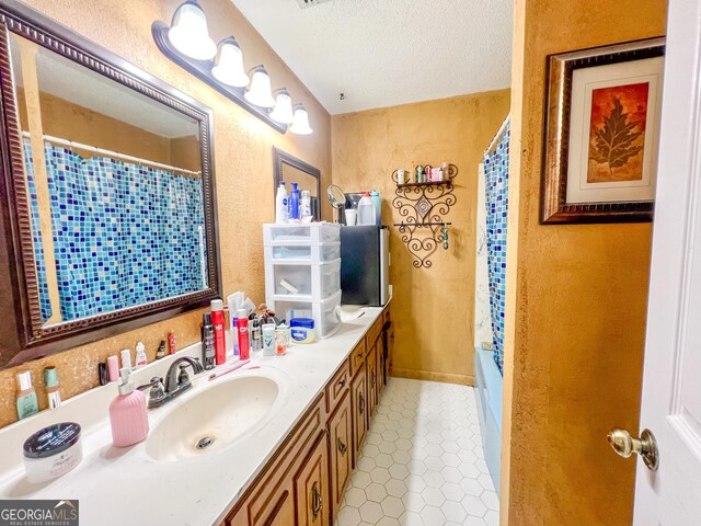 bathroom featuring vanity, tile patterned flooring, and a textured ceiling